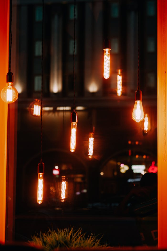 A cozy atmosphere created by hanging Edison bulbs glowing warmly in a dark room.