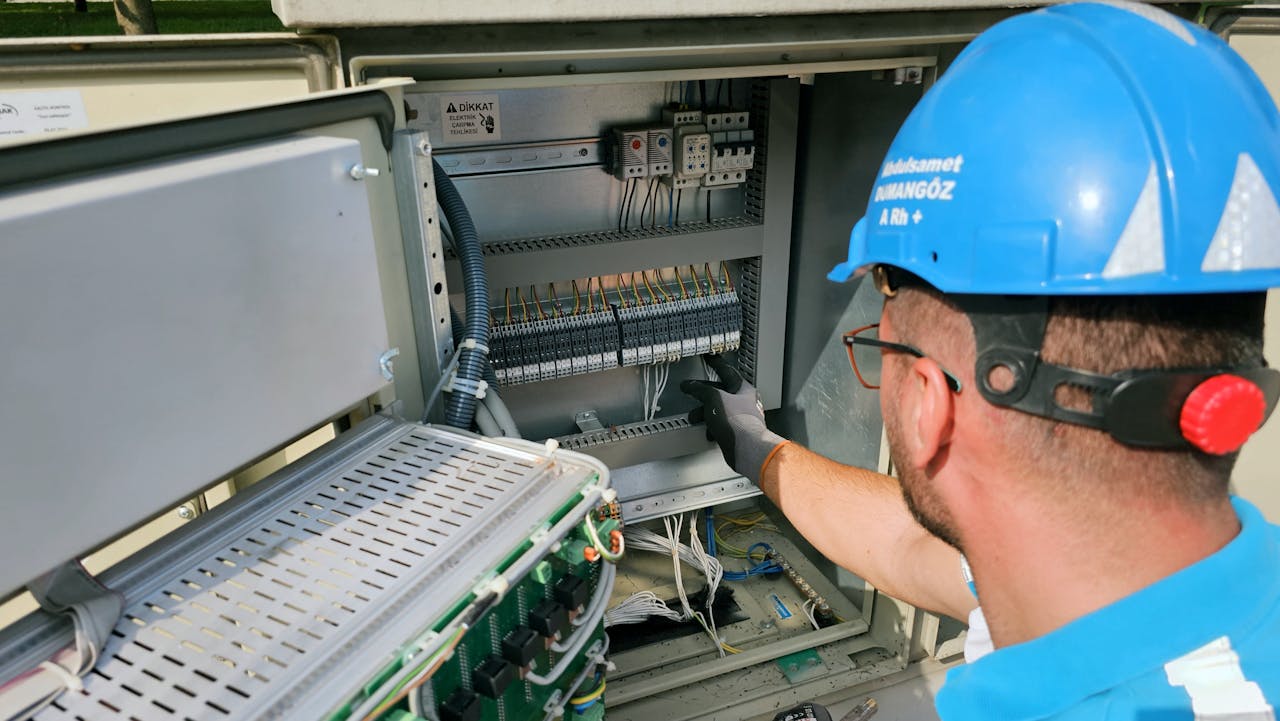 Services An electrician works on an outdoor fusebox, ensuring safety and functionality.